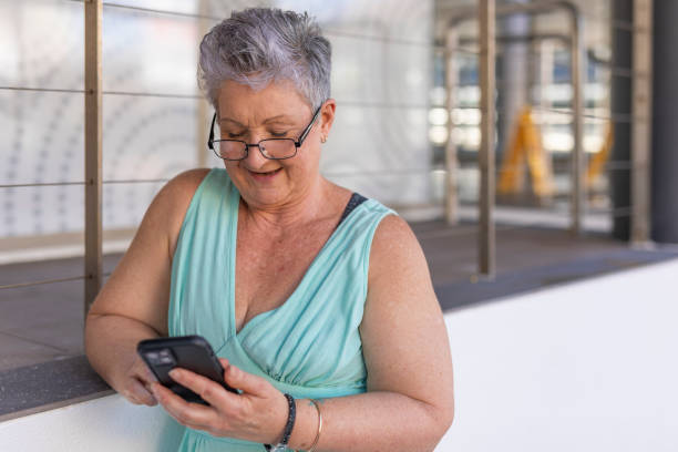 istock Senior woman using a mobile phone outdoors 1427501782