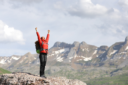 Hiker raising arms celebrating in a high mountain
