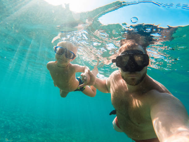 istock Happy Boy Enjoying At The Beach While On Vacations With His Dad 1427506821