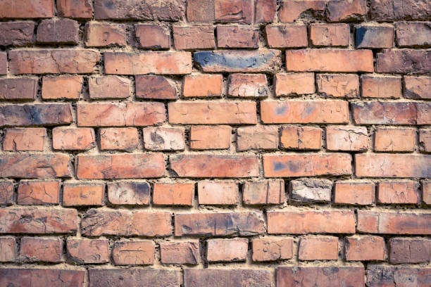 istock Red old worn brick wall background. Vintage effect. Abstract pattern of bricks. Grunge concrete backdrop. Brown cement texture. Construction material for decoration design, architecture, rough surface 1427508728
