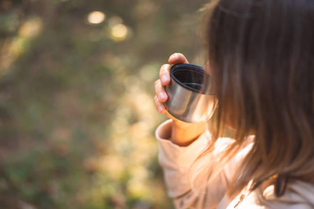 istock young woman pouring tea in a pine forest 1427508772