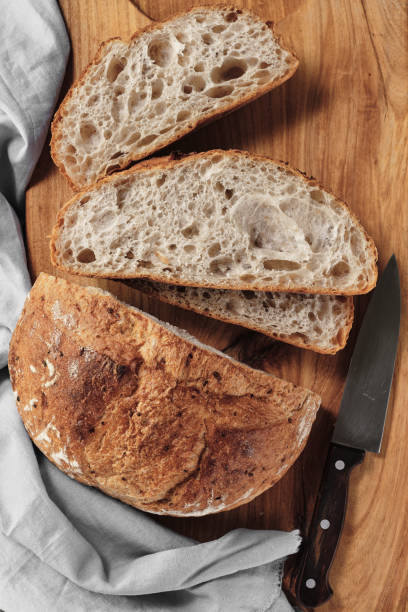 istock Sliced loaf of artisan sourdough bread on a cutting board. Top view, vertical frame 1427511179
