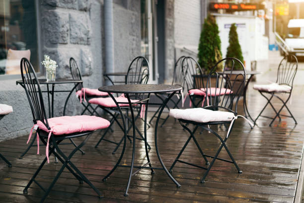 istock empty cafe tables on the street during the rain.  selective focus 1427511241