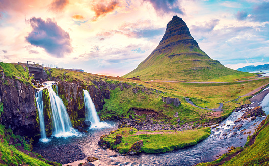 Beautiful natural magical scenery with a waterfall Kirkjufell near the volcano at dawn  in Iceland. Exotic countries. Amazing places. Popular tourist atraction. (Meditation, antistress - concept).