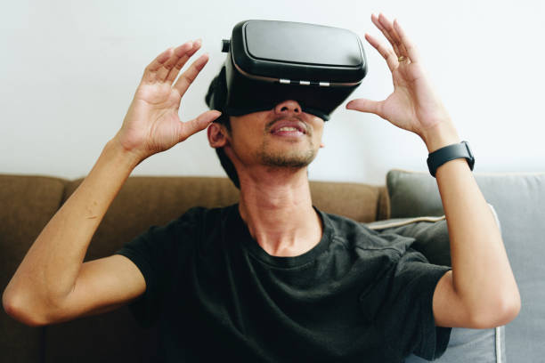 istock portrait of a young Asian man using virtual reality simulator headset at home 1427511611