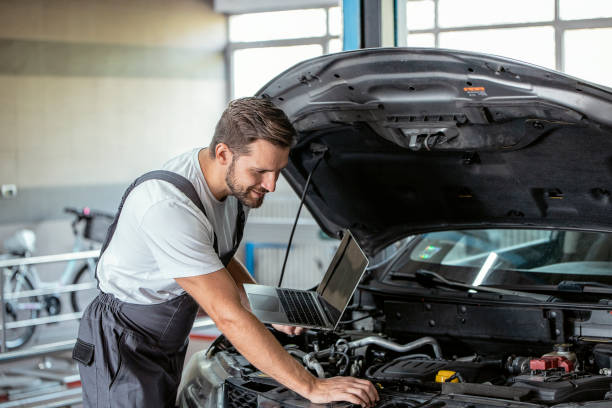 istock Mechanic using Laptop while Repairing Car 1427512233