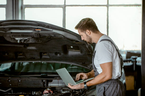 istock Mechanic using Laptop while Repairing Car 1427512397