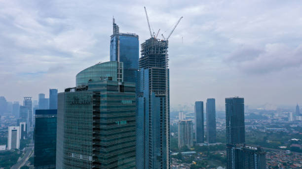 istock Construction of high-rise skyscrapers with many floors using cranes. This building is a place of work for trade and business center. Twin tower building 1427516998