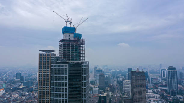 istock Construction of high-rise skyscrapers with many floors using cranes. This building is a place of work for trade and business center. Twin tower building 1427517000