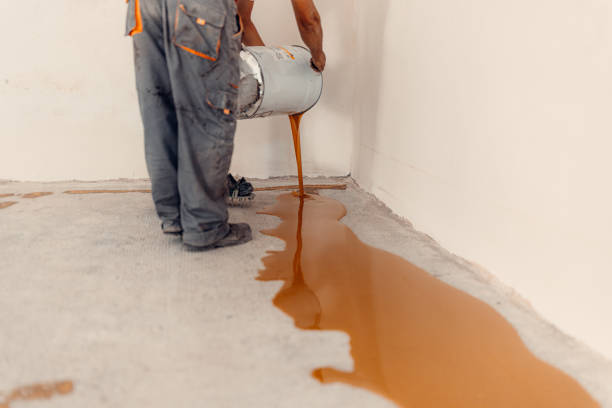 istock Worker applying a yellow epoxy resin bucket on floor. 1427517009
