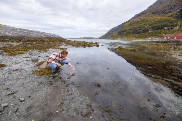 istock Man bends down to cup water with hand 1427517446