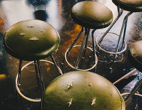 Old moss green bar stools in a bar at the counter.