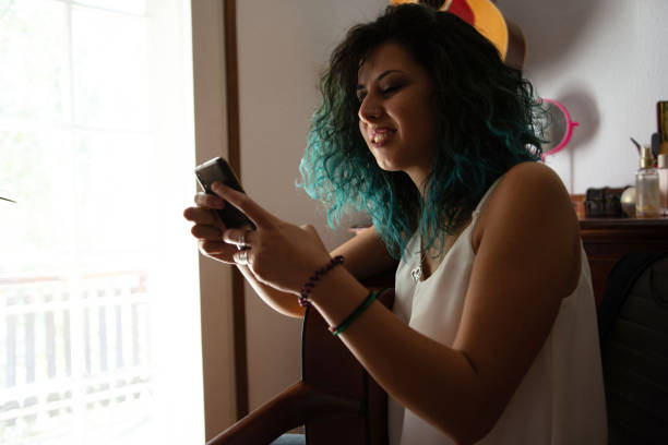 istock Young woman playing a guitar at home 1427517665