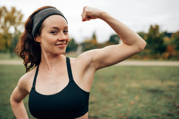 筋肉を示すフィットネスの女性 - human muscle women bicep girl power ストックフォトと画像