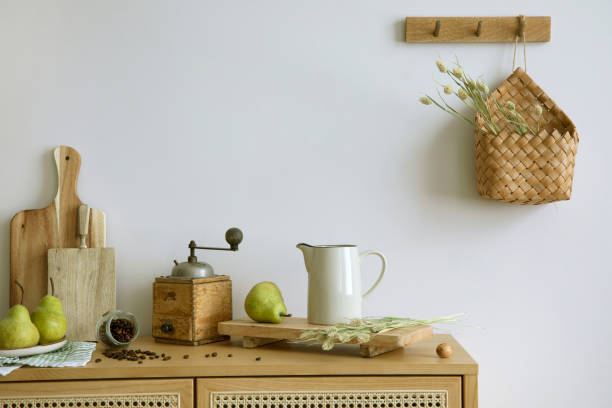 istock Stylish interior of kitchen space with rattan commode,  ladder, pears, food and kitchen accessories in modern home decor.  Template. 1427519010