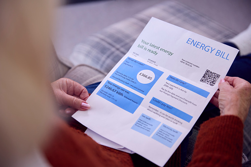 Primer plano de una mujer mayor en casa mirando la factura de energía durante la crisis energética del costo de vida photo