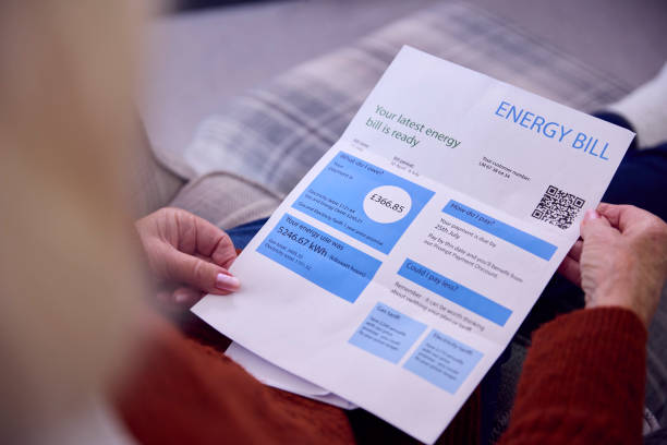 生活費エネルギー危機の間にエネルギー法案を見ている自宅で高齢者女性のクローズアップ - energy bill ストックフォトと画像