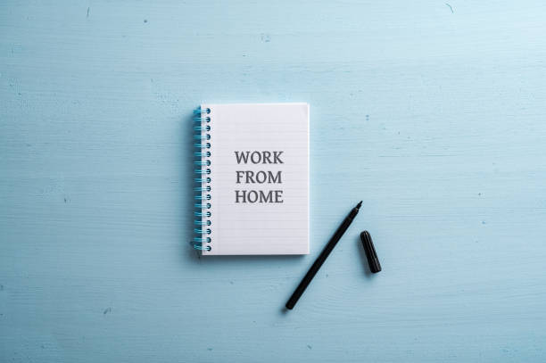 istock Open spiral notebook with a Work from home sign written in it 1427520092