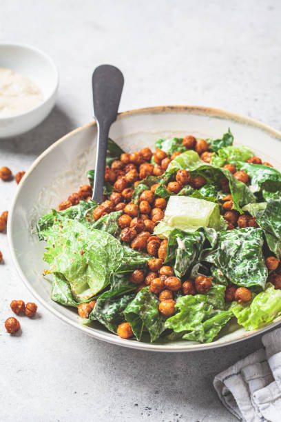 istock Vegan caesar salad with fried spicy chickpeas in a gray bowl. 1427522760
