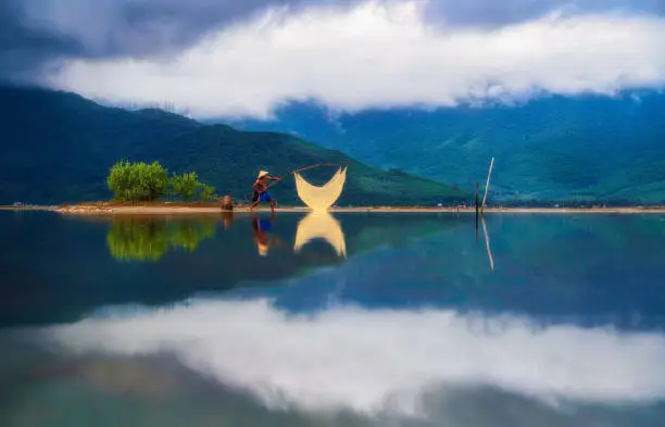 Fisherman in Lap An lagoon is pulling fishing trap on the water - Lap An, Lang Co town, Thua Thien Hue province, central Vietnam