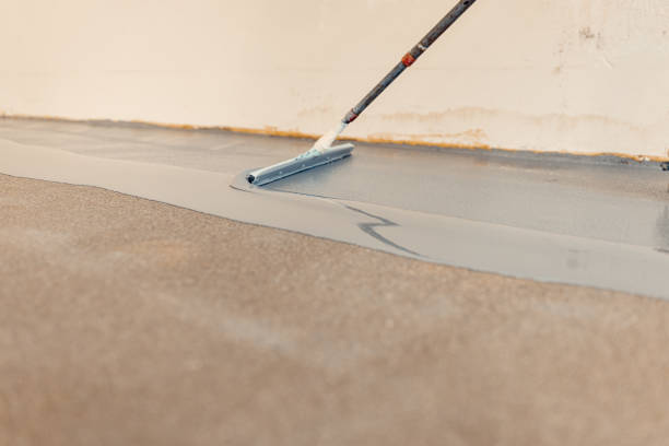istock A construction worker applying grey epoxy resin in an industrial hall 1427524256