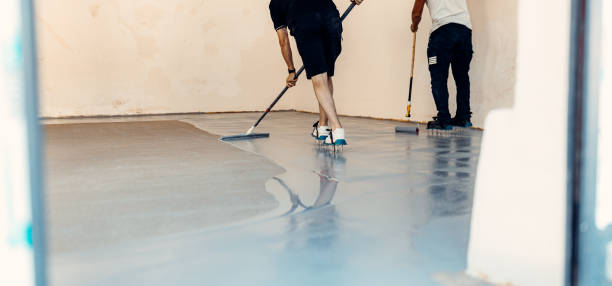 istock A construction worker apply grey epoxy resin in an industrial hall 1427524572