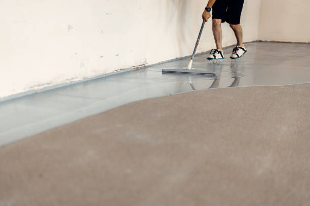 istock A construction worker apply grey epoxy resin in an industrial hall 1427524877