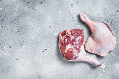 Fresh raw duck legs on a kitchen table. Gray background. Top view. Copy space