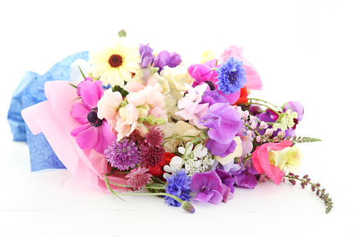 Florist at work: woman making fashion modern bouquet of different flowers on wooden background. Masterclass. Gift for bride on wedding, mother's, woman's day. Romantic spring fashion. Innocence tender.