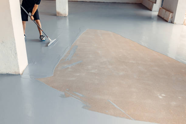 istock A construction worker apply grey epoxy resin in an industrial hall 1427526864