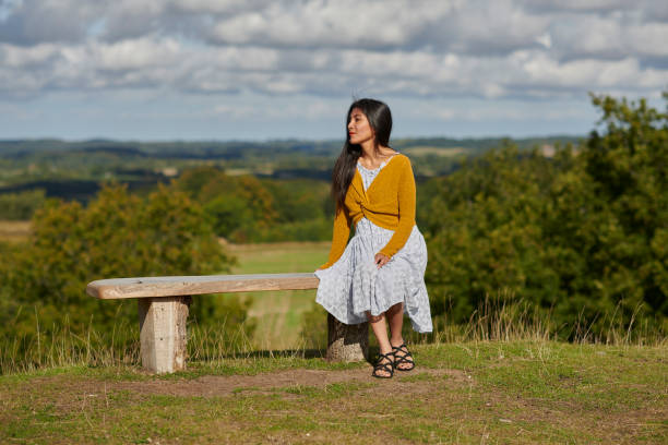 istock Autumn mood with young woman outdoors sitting on bench 1427528255
