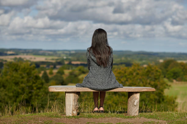 istock Autumn mood with young woman outdoors sitting on bench 1427528332