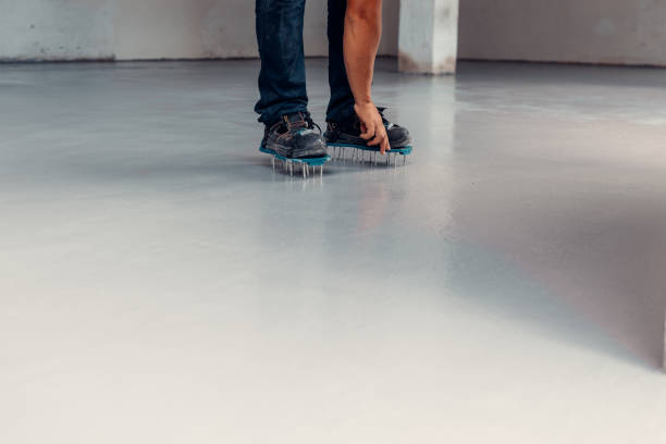 istock A construction worker apply grey epoxy resin in an industrial hall 1427528469