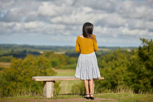istock Autumn mood with young woman outdoors standing at bench 1427529266