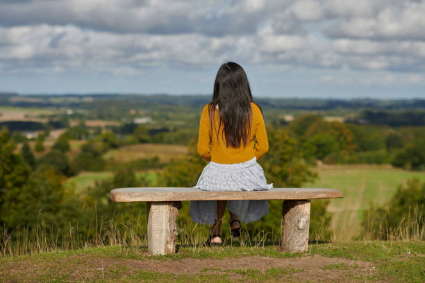 istock Autumn mood with young woman outdoors sitting on bench 1427529347