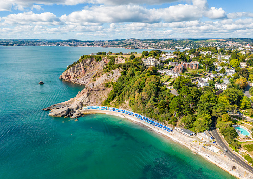 Beach huts at Meadfoot beach and coastline in Torquay