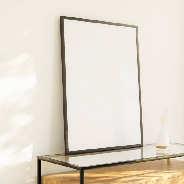 istock Interior mockup - Living room with a blank picture frame on a sideboard leaning against the wall. Luminous pattern light effect. Porcelain vase with room fragrance sticks. 1427531314