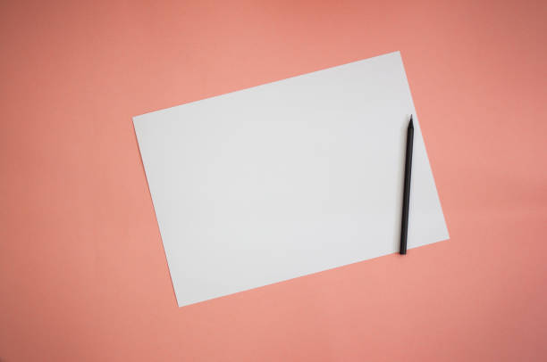 istock White card and black pencil on a pink background. 1427533924