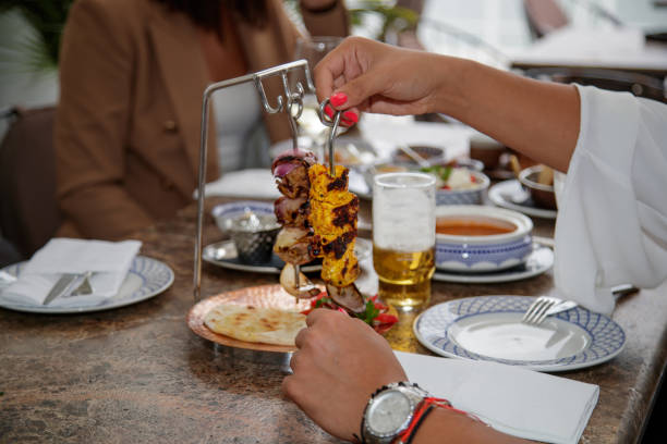 istock Taking skewer with meat and vegetables down from special stand in ethnic restaurant 1427534523