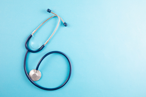 Blue stethoscope on blue background with copy space