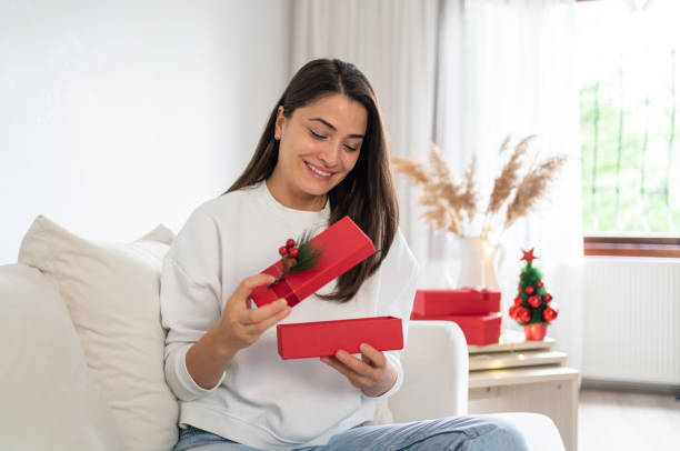 istock Smiling Woman Opening Gift Wrap 1427536793