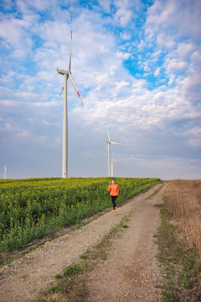 istock Going for a run in agricultural field with wind turbines 1427540795