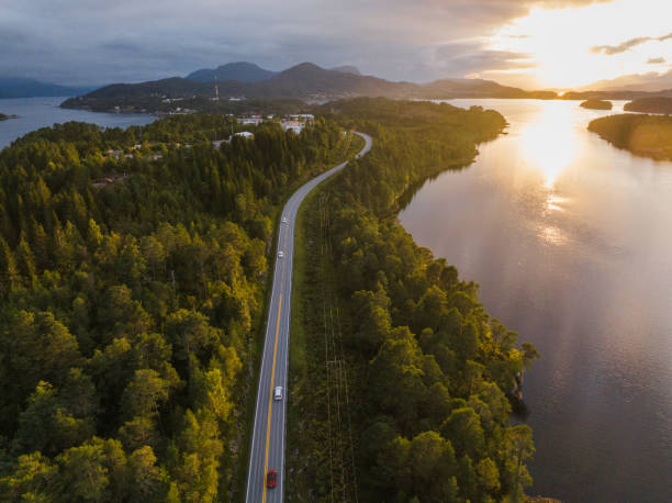 日没時のノルウェーの湖の近くの道路上の車の空撮 - aerial view nature nordic countries island ストックフォトと画像