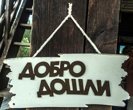 Wooden Sign with the Inscription Welcome in Cyrillic, Ethnic Village in Serbia