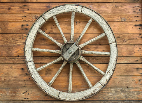 wooden cart wheel on the wall of a wooden house