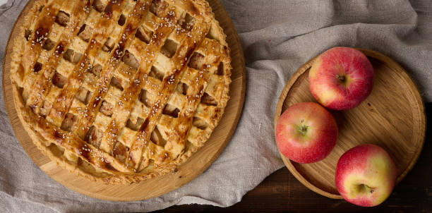 istock Round baked apple pie on a brown wooden table, top view 1427543498
