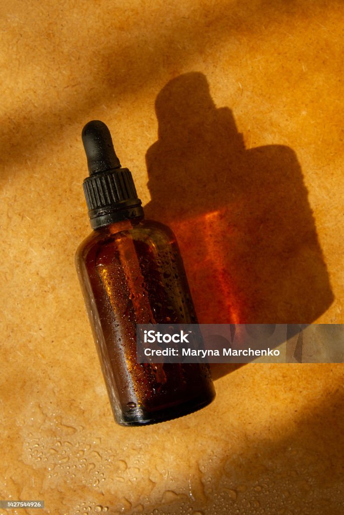 Natural cosmetic jar. Brown color. Sunlight cosmetics. Natural cosmetics, water drops. Pharmacy, laboratory, natural cosmetics. Amber Stock Photo