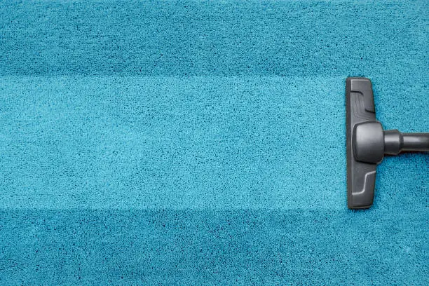 Vacuum cleaner on the blue carpet floor