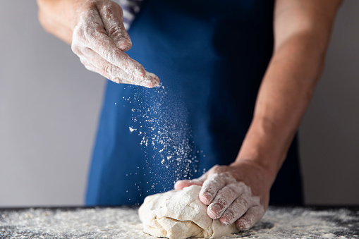 Baking traditional Italian colomba cake with candied fruit in the shape of a dove to celebrate Easter with the raw dough in a baking tin on a bakery table