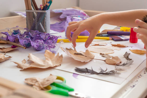 istock An unrecognizable child doing autumn handcrafts on a white wooden table. 1427547055